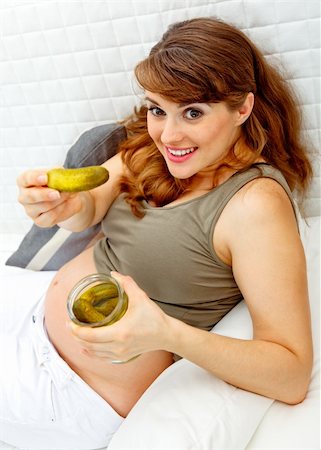 simsearch:400-05911635,k - Smiling beautiful pregnant woman relaxing on sofa at home and  holding  jar of pickles in hands Foto de stock - Super Valor sin royalties y Suscripción, Código: 400-04268422