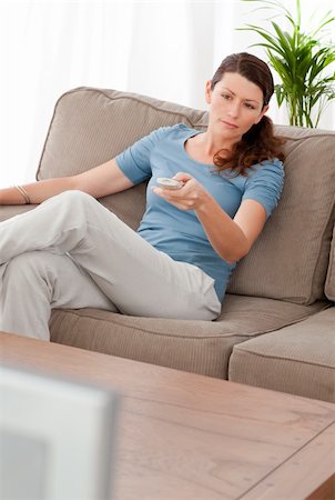 simsearch:400-04268918,k - Serious woman changing channel while relaxing in the living-room at home Stockbilder - Microstock & Abonnement, Bildnummer: 400-04268917