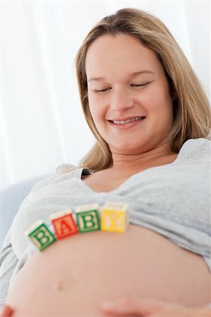 simsearch:400-04767824,k - Portrait of a future mom with baby letters on her belly and smiling at the camera Foto de stock - Royalty-Free Super Valor e Assinatura, Número: 400-04268964