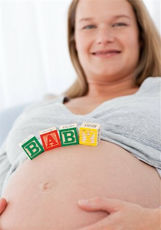 simsearch:400-04767824,k - Portrait of a future mom with baby letters on her belly and smiling at the camera Foto de stock - Royalty-Free Super Valor e Assinatura, Número: 400-04268962