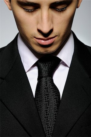 simsearch:400-04150475,k - Portrait of succesful  business man in formal suit and black tie looking down. gray background Foto de stock - Super Valor sin royalties y Suscripción, Código: 400-04260770