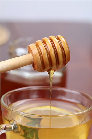 Honey dipper with honey pouring into a cup of tea with lemon Stock Photo - Budget Royalty-Free & Subscription, Code: 400-04260916