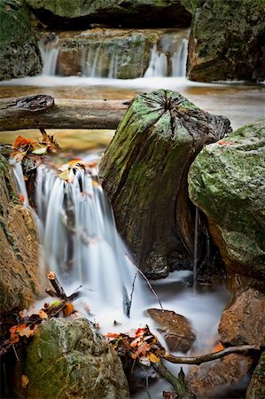 rocks and wood in autumn river rapid long exposure results in smooth surface and surreal blurred water Stock Photo - Budget Royalty-Free & Subscription, Code: 400-04260920