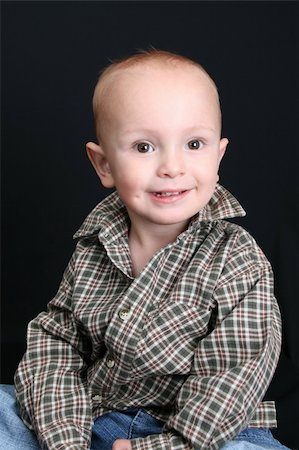 Blonde toddler against a black background with a smile Stock Photo - Budget Royalty-Free & Subscription, Code: 400-04261073