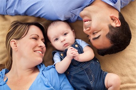 Mixed Race Family Playing Face Up on the Blanket. Stock Photo - Budget Royalty-Free & Subscription, Code: 400-04261345