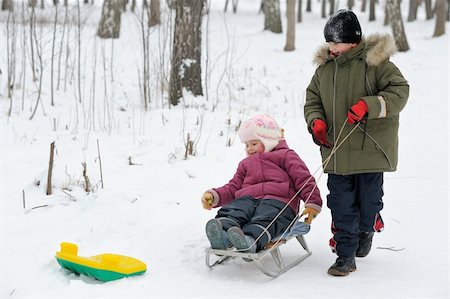 simsearch:400-05909257,k - Winter games children - a girl on a sledge and a boy next. Photographie de stock - Aubaine LD & Abonnement, Code: 400-04262017