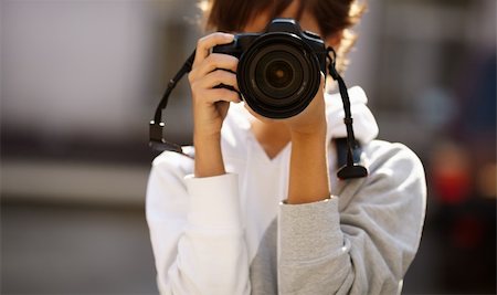 female photographer with professional SLR camera, natural light, selective focus on nearest part of lens with blend Stock Photo - Budget Royalty-Free & Subscription, Code: 400-04262904