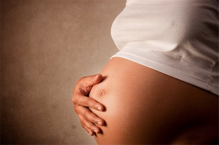 simsearch:400-05084530,k - Pregnant woman holding her belly  over dark background Foto de stock - Super Valor sin royalties y Suscripción, Código: 400-04275036