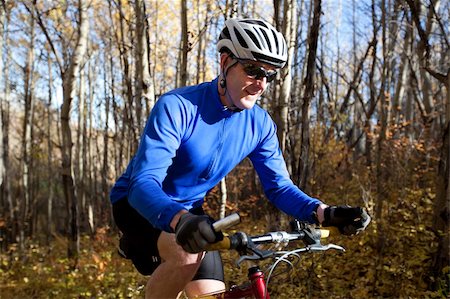 simsearch:400-04336549,k - Middle aged man mountain biking on forest trail. Fotografie stock - Microstock e Abbonamento, Codice: 400-04275235