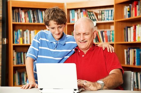 person reading a book confused - Father and son surfing the internet at the school library. Stock Photo - Budget Royalty-Free & Subscription, Code: 400-04276103