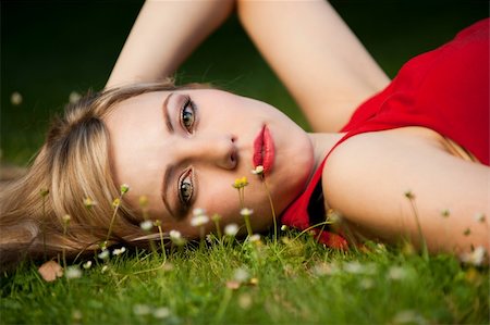 simsearch:400-09224445,k - Portrait of a woman with beautiful eyes in a red dress lying on the grass. Foto de stock - Super Valor sin royalties y Suscripción, Código: 400-04276120