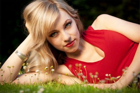 simsearch:400-09224445,k - Portrait of a woman with beautiful eyes in a red dress lying on the grass. Foto de stock - Super Valor sin royalties y Suscripción, Código: 400-04276121