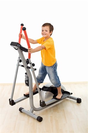 simsearch:400-03994929,k - Smiling boy playing on elliptical trainer in the gym - isolated Stockbilder - Microstock & Abonnement, Bildnummer: 400-04276214