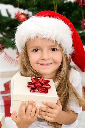 Adorable little girl holding present wearing a christmas hat - closeup Stock Photo - Budget Royalty-Free & Subscription, Code: 400-04276239