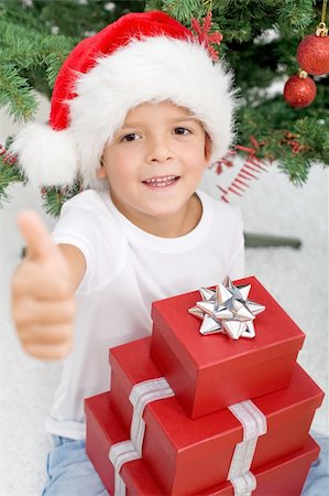 simsearch:400-06132090,k - Happy boy satisfied with christmas presents - showing thumb up sign Photographie de stock - Aubaine LD & Abonnement, Code: 400-04276230