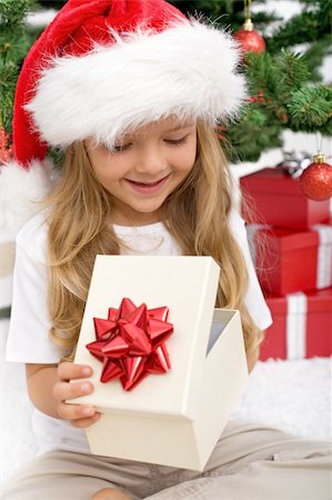 simsearch:400-05008640,k - Little girl opening present in front of christmas tree - closeup Photographie de stock - Aubaine LD & Abonnement, Code: 400-04276233