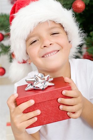 simsearch:400-06477682,k - Happy boy smiling, holding christmas present - closeup Stock Photo - Budget Royalty-Free & Subscription, Code: 400-04276240