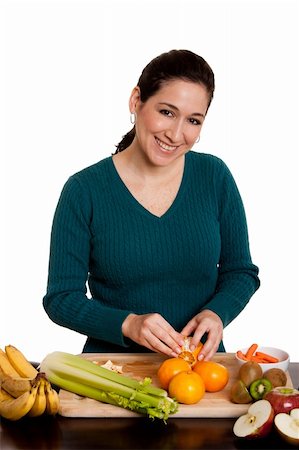 Beautiful happy woman in kitchen peeling orange preparing fruits for juice or salad, isolated. Photographie de stock - Aubaine LD & Abonnement, Code: 400-04276617