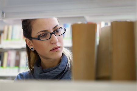 simsearch:6108-06166190,k - female college student taking book from shelf in library. Horizontal shape, front view, head and shoulders, copy space Stockbilder - Microstock & Abonnement, Bildnummer: 400-04276882