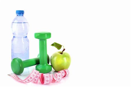 Dumbbells, green apple, measuring tape and a bottle of water isolaeted on white Foto de stock - Royalty-Free Super Valor e Assinatura, Número: 400-04276904