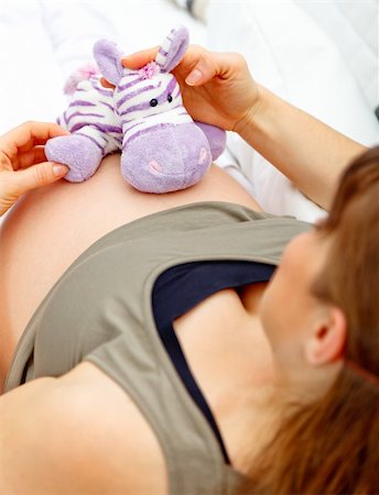 simsearch:400-05911635,k - Pregnant woman sitting on sofa at home and holding toy on her belly. Foto de stock - Super Valor sin royalties y Suscripción, Código: 400-04277518