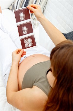 simsearch:400-04688796,k - Pregnant woman relaxing on couch at home and looking echo. Close-up. Fotografie stock - Microstock e Abbonamento, Codice: 400-04277525