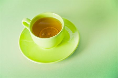 simsearch:400-04232483,k - The cup of green tea with lemon on green background Stock Photo - Budget Royalty-Free & Subscription, Code: 400-04279779