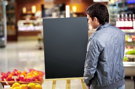 shopping mall advertising - The young man looks at an empty board in shop Stock Photo - Budget Royalty-Free & Subscription, Code: 400-04271148