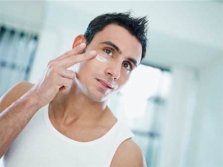 face cream male - young caucasian man applying eye cream on face. Horizontal shape, front view, head and shoulders Stock Photo - Budget Royalty-Free & Subscription, Code: 400-04271393