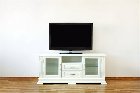 Large widescreen TV set on the white dresser in a bright room. Foto de stock - Super Valor sin royalties y Suscripción, Código: 400-04286414