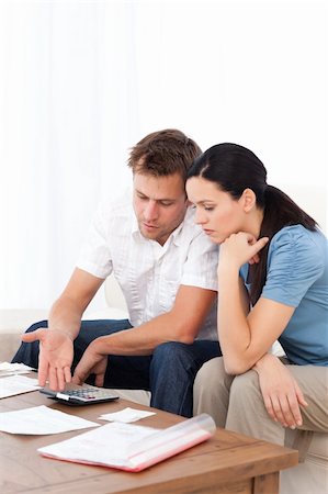 simsearch:400-05746763,k - Desperate couple doing their account sitting on the sofa of the living room Stock Photo - Budget Royalty-Free & Subscription, Code: 400-04286966