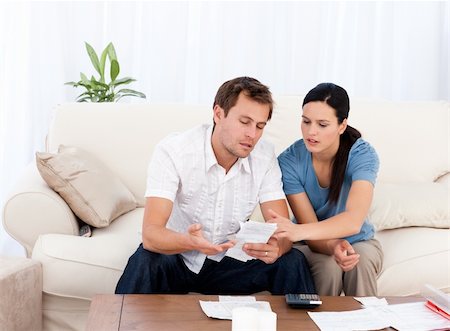 simsearch:400-05746763,k - Man showing a bill to his girlfriend sitting on the sofa at home Stock Photo - Budget Royalty-Free & Subscription, Code: 400-04286967