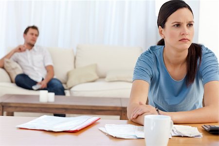 simsearch:400-05746763,k - Angry woman doing her account while her boyfriend relaxing on the sofa Stock Photo - Budget Royalty-Free & Subscription, Code: 400-04286969