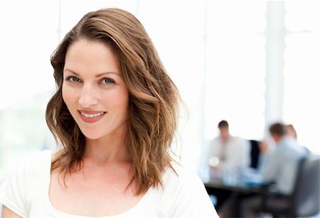 simsearch:400-04287075,k - Relaxed businesswoman standing in front of her team while working at a table Fotografie stock - Microstock e Abbonamento, Codice: 400-04287075