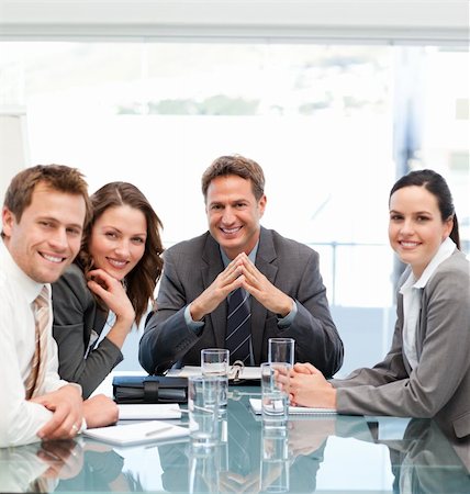 simsearch:400-04287075,k - Portrait of a positive manager with his team sitting at a table Fotografie stock - Microstock e Abbonamento, Codice: 400-04287070