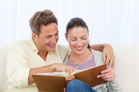 simsearch:400-04151970,k - Couple smiling while looking at pictures on a photo album at home Fotografie stock - Microstock e Abbonamento, Codice: 400-04287259