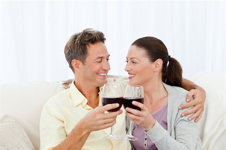 Passionate couple drinking red wine while relaxing on the sofa Stock Photo - Budget Royalty-Free & Subscription, Code: 400-04287260