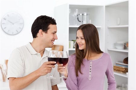 Lovely couple giving a toast with red wine standing in the kitchen Stock Photo - Budget Royalty-Free & Subscription, Code: 400-04287290