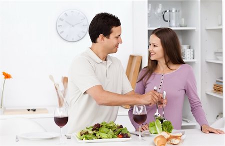 Attentive man serving salad to his girlfriend standing in the kitchen Stock Photo - Budget Royalty-Free & Subscription, Code: 400-04287293