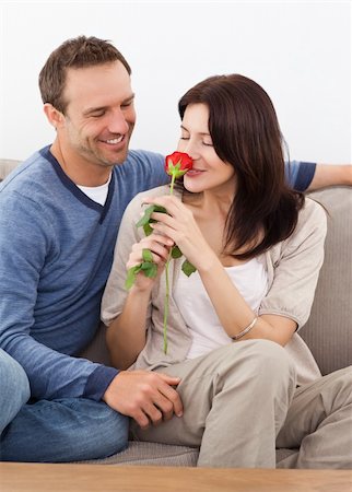 simsearch:400-07726699,k - Cute woman smelling a red rose while relaxing on the sofa with her boyfriend Foto de stock - Super Valor sin royalties y Suscripción, Código: 400-04287300