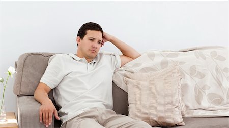 simsearch:695-05772340,k - Depressed man thinking on the sofa alone at home Foto de stock - Royalty-Free Super Valor e Assinatura, Número: 400-04287345