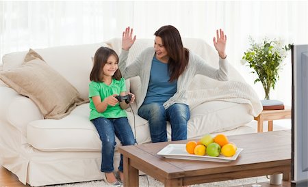 simsearch:400-05297936,k - Cheerful mom looking at her daughter playing video games in the living room Stock Photo - Budget Royalty-Free & Subscription, Code: 400-04287352