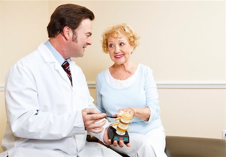 Chiropractor uses a model of the human spine to explain treatment to a new patient. Stock Photo - Budget Royalty-Free & Subscription, Code: 400-04287460