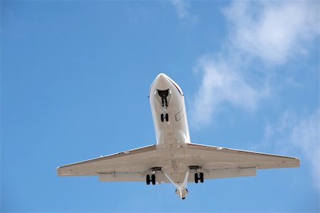 business jet on landing approach against a blue sky Foto de stock - Super Valor sin royalties y Suscripción, Código: 400-04288046