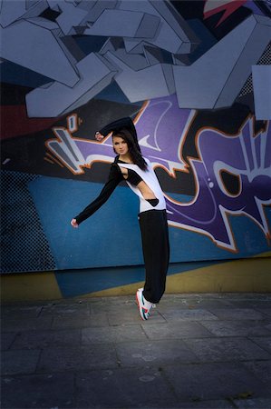 simsearch:400-04872117,k - young attractive woman in hip hop dress dancing and posing near a wall with graffiti Foto de stock - Royalty-Free Super Valor e Assinatura, Número: 400-04288066
