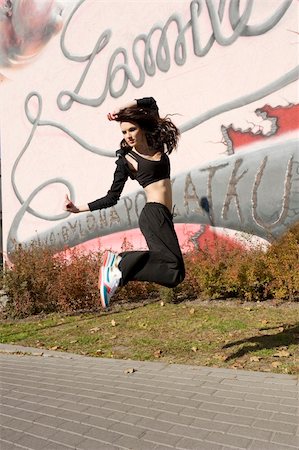 funky cartoon girls - nice brunette dancer jumping in informal dress near a wall with a graffiti Stock Photo - Budget Royalty-Free & Subscription, Code: 400-04288067