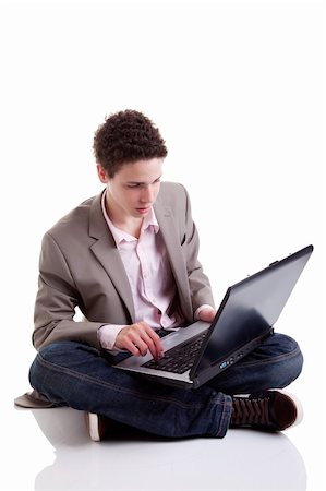 Young man typing and looking at screen of laptop, isolated on white, studio shot Photographie de stock - Aubaine LD & Abonnement, Code: 400-04288451