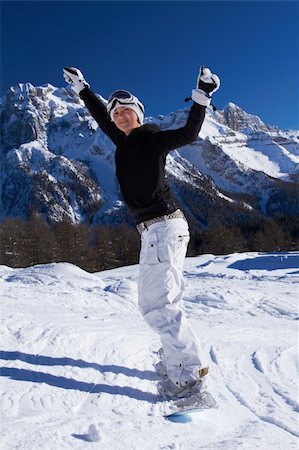 extreme cold clothes women - Beautiful girl on snowboard with both hands rised Stock Photo - Budget Royalty-Free & Subscription, Code: 400-04289178