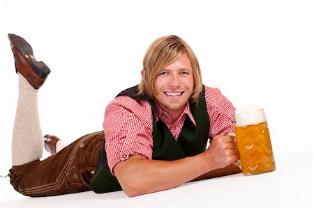 simsearch:400-04680527,k - Happy man lying on floor holding oktoberfest beer stein. Isolated on white background. Stockbilder - Microstock & Abonnement, Bildnummer: 400-04280494