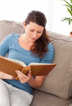 simsearch:400-04268918,k - Attentive woman reading a book sitting on her sofa at home Stockbilder - Microstock & Abonnement, Bildnummer: 400-04281541